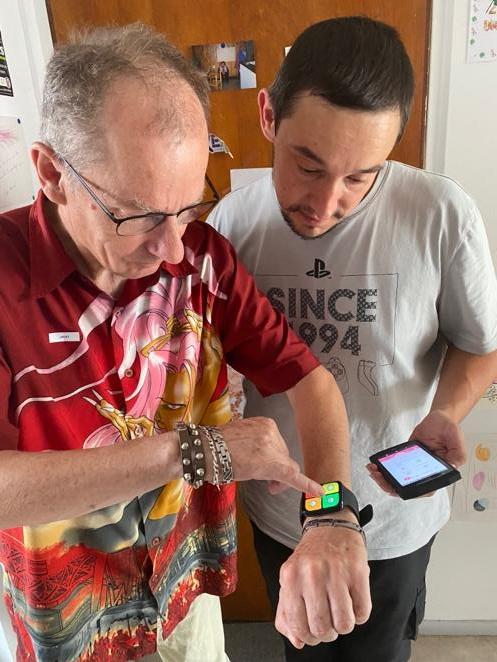 Deux personnes interagissent avec un smartphone et une montre connecté dans une optique de test